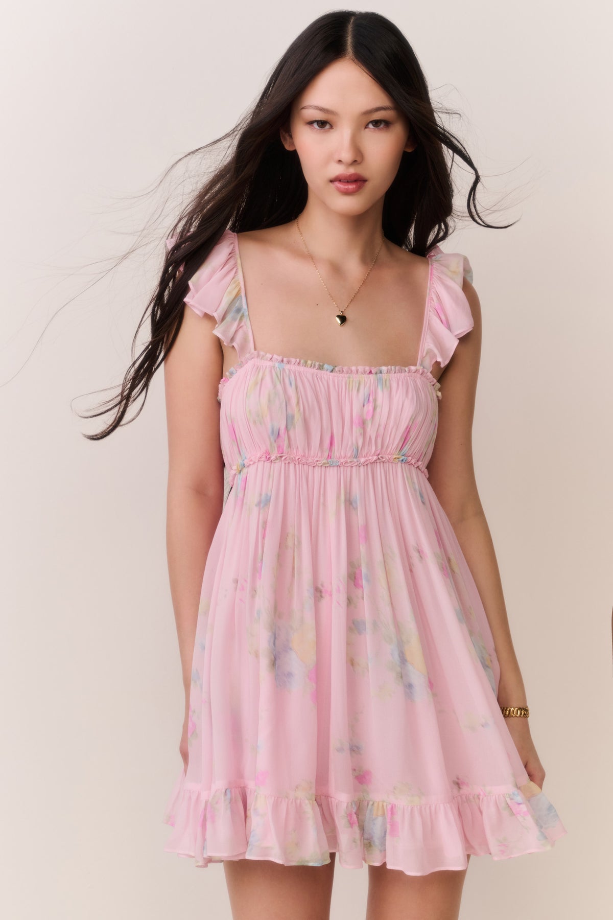 Pink floral chiffon mini dress with smocked bodice and flutter ruffle sleeves, tiered hem