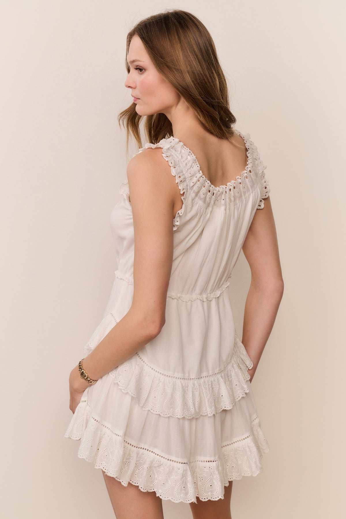White sleeveless mini dress with ruffled tiers and lace-trim shoulder detail