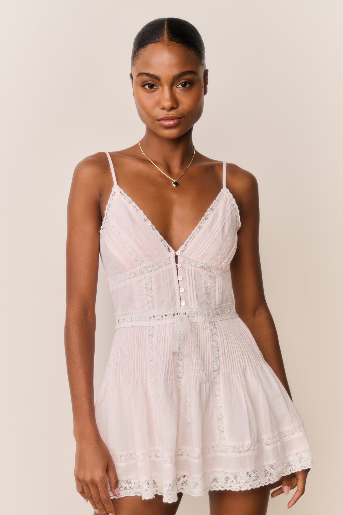 Light pink cotton mini dress with V-neck, button front, and lace-trim skirt