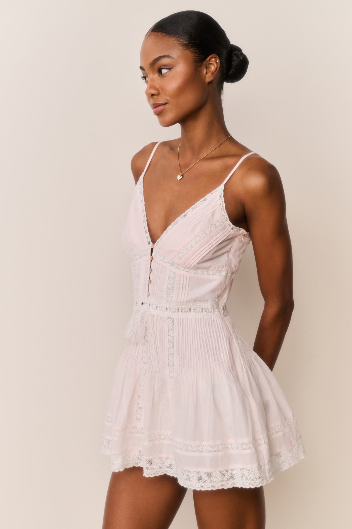 Light pink cotton mini dress with V-neckline, button-front bodice, lace trim