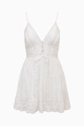 White cotton mini dress with V-neck spaghetti straps, lace trim, flared tiered skirt