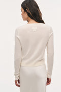 Ivory wool sweater with long sleeves and lace bow detail at the back