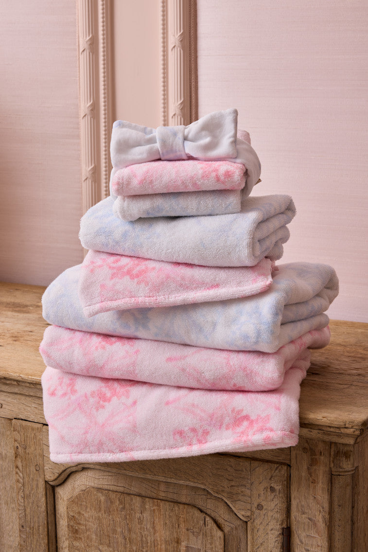 Cotton hand towel stack in light blue and pink with subtle floral pattern, folded