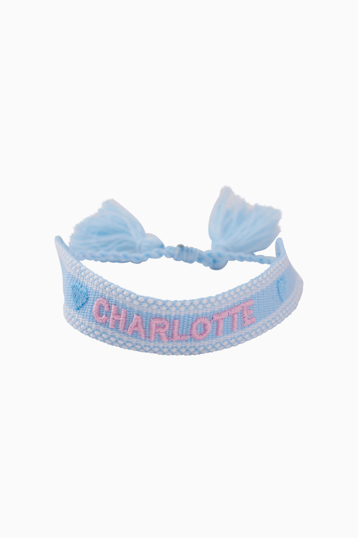 Woven fabric bracelet in light blue with braided cord and bow accents