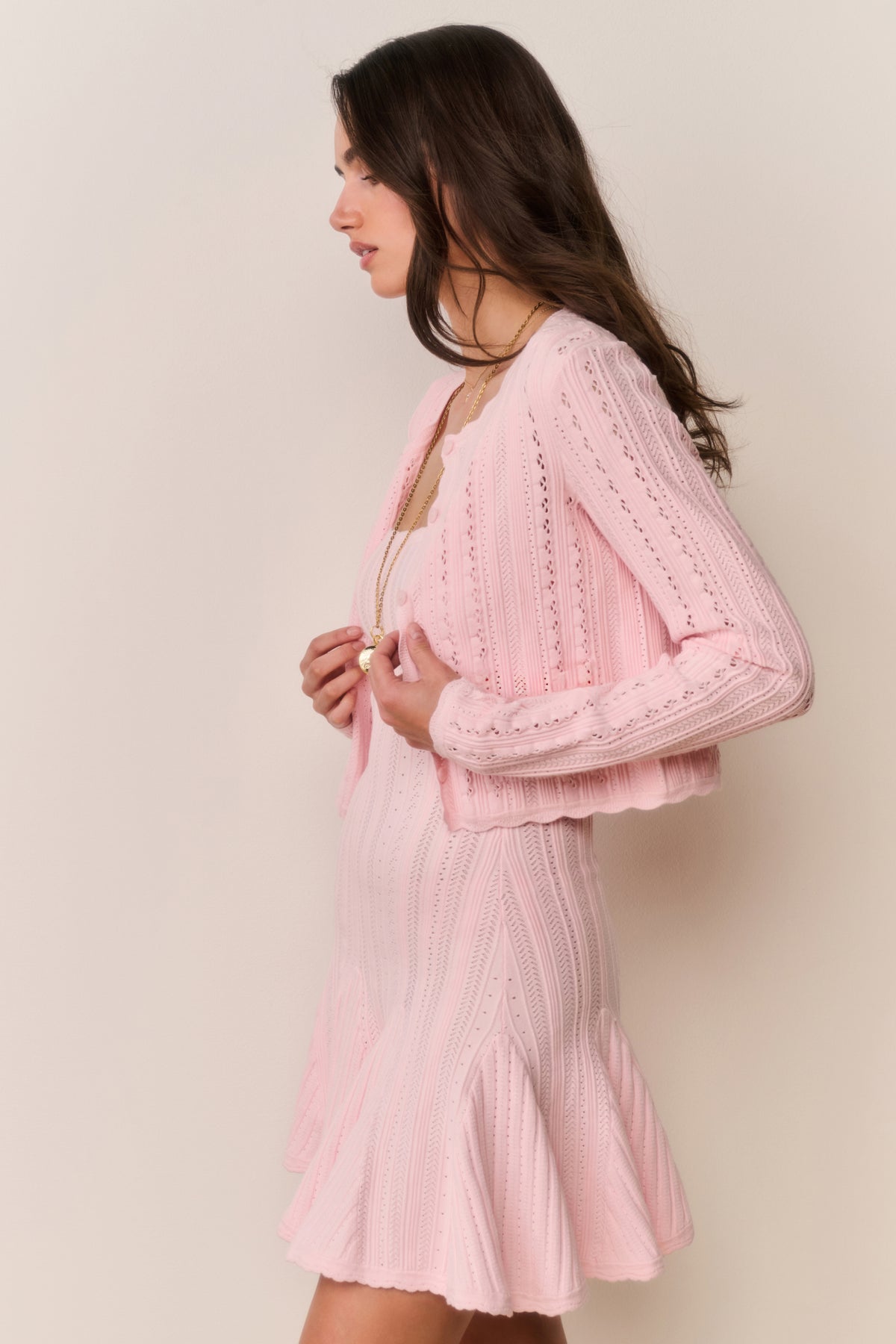 Pink pointelle knit cardigan, side view with long sleeves and button front