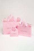Pink patterned gift bags set with ribbon handles and a bow-topped bag