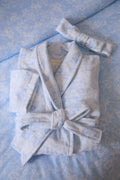 Light blue floral cotton bathrobe detail: tied belt at waist and shawl collar