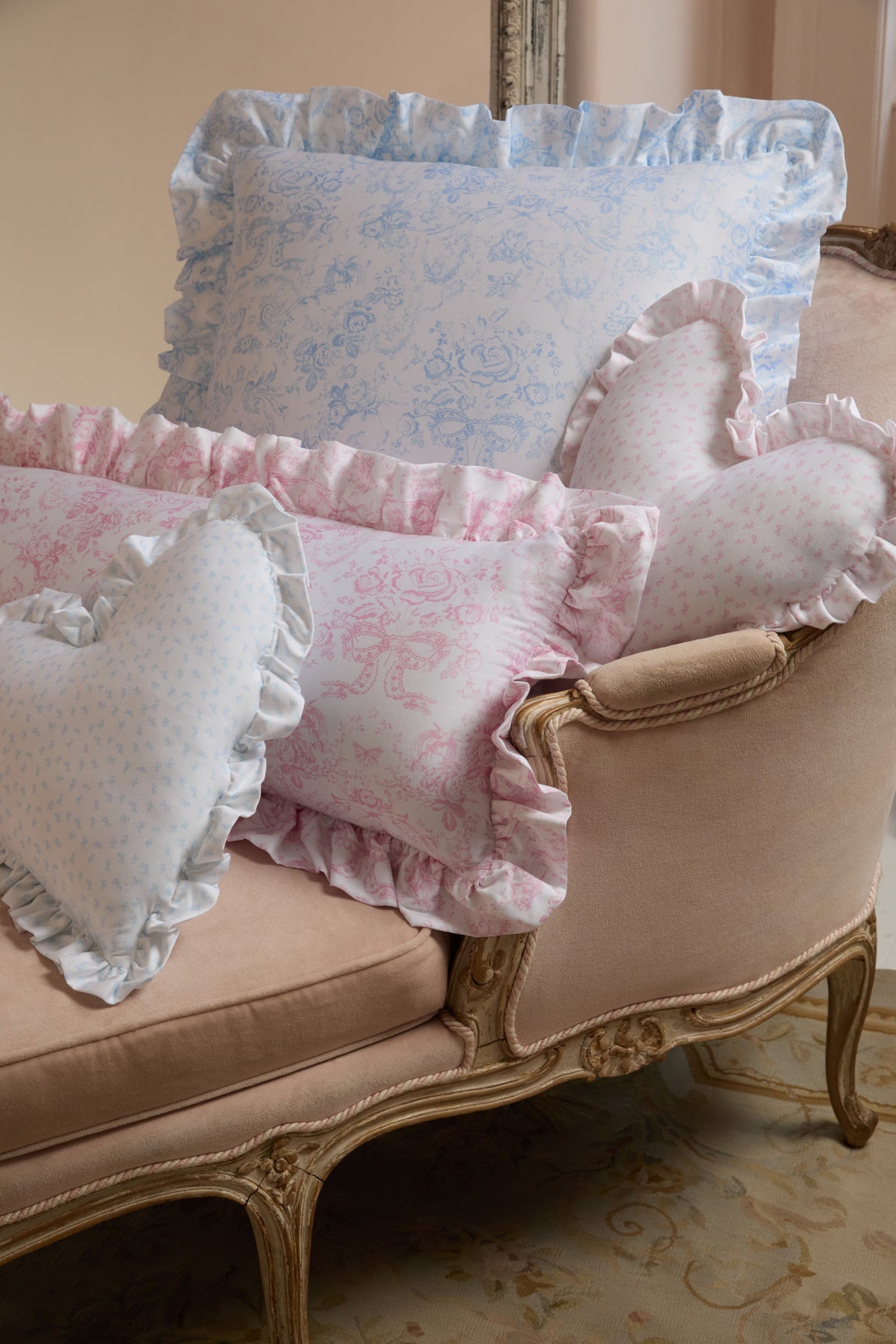 Pink and light blue ruffle throw pillows with gathered edges on a sofa
