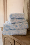 Cotton bath towel set, light blue floral bow print, folded stack with plush terry.