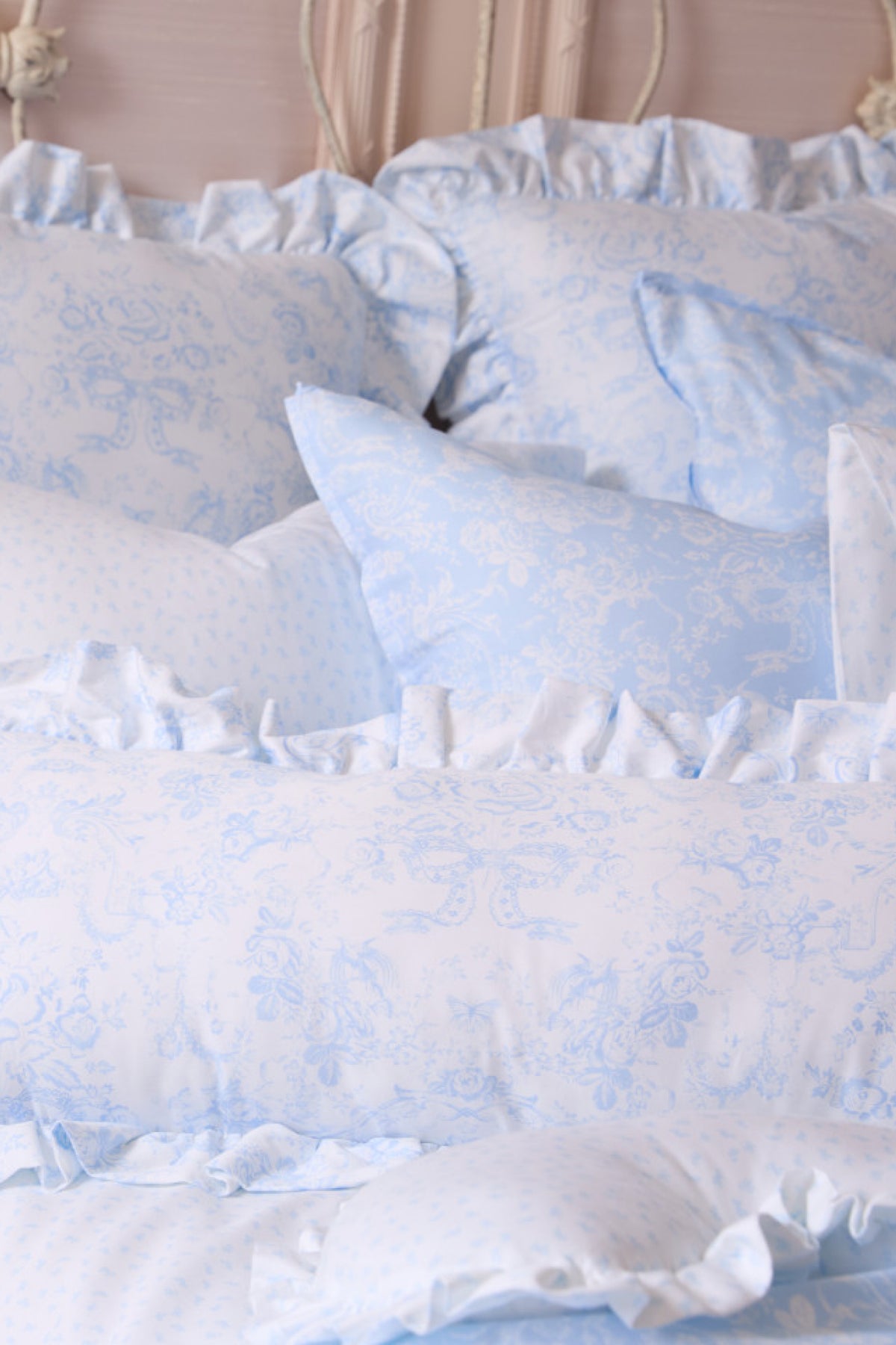 Light blue floral ruffle throw pillows with gathered edge trim in layered arrangement