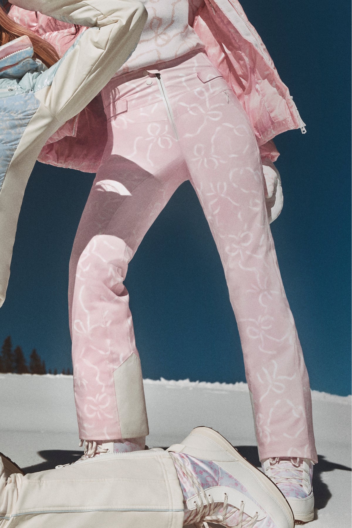 Close-up of light pink patterned ski pants with zipper fly and belt loops