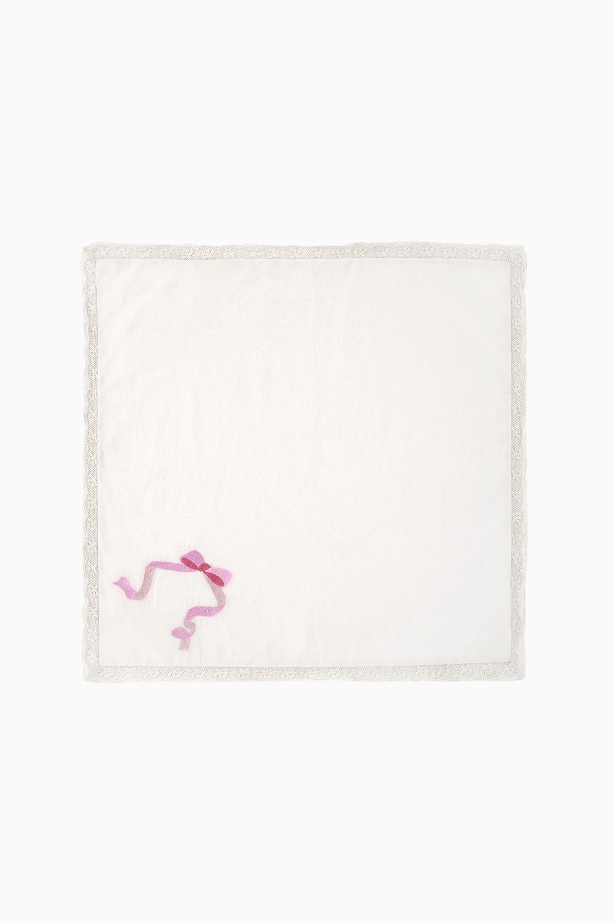 White embroidered napkin with pink motif at corner and lace-trim border