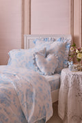 Light blue printed duvet cover set with two ruffled shams and floral motifs