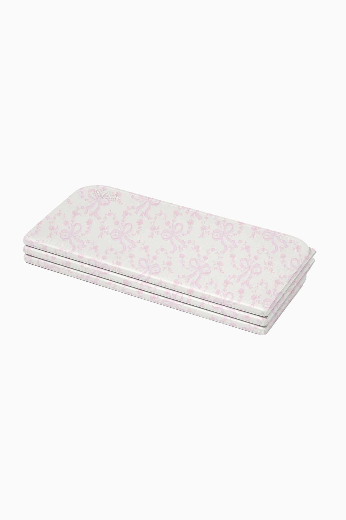 Folded light pink floral yoga mat with layered edges