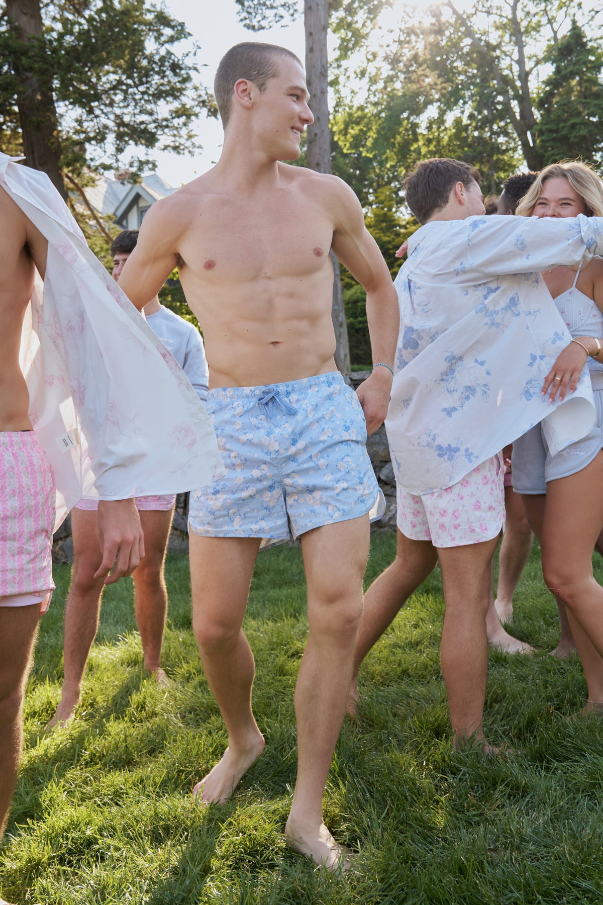 Floral print swim shorts with elastic waistband and drawstring, light blue base.