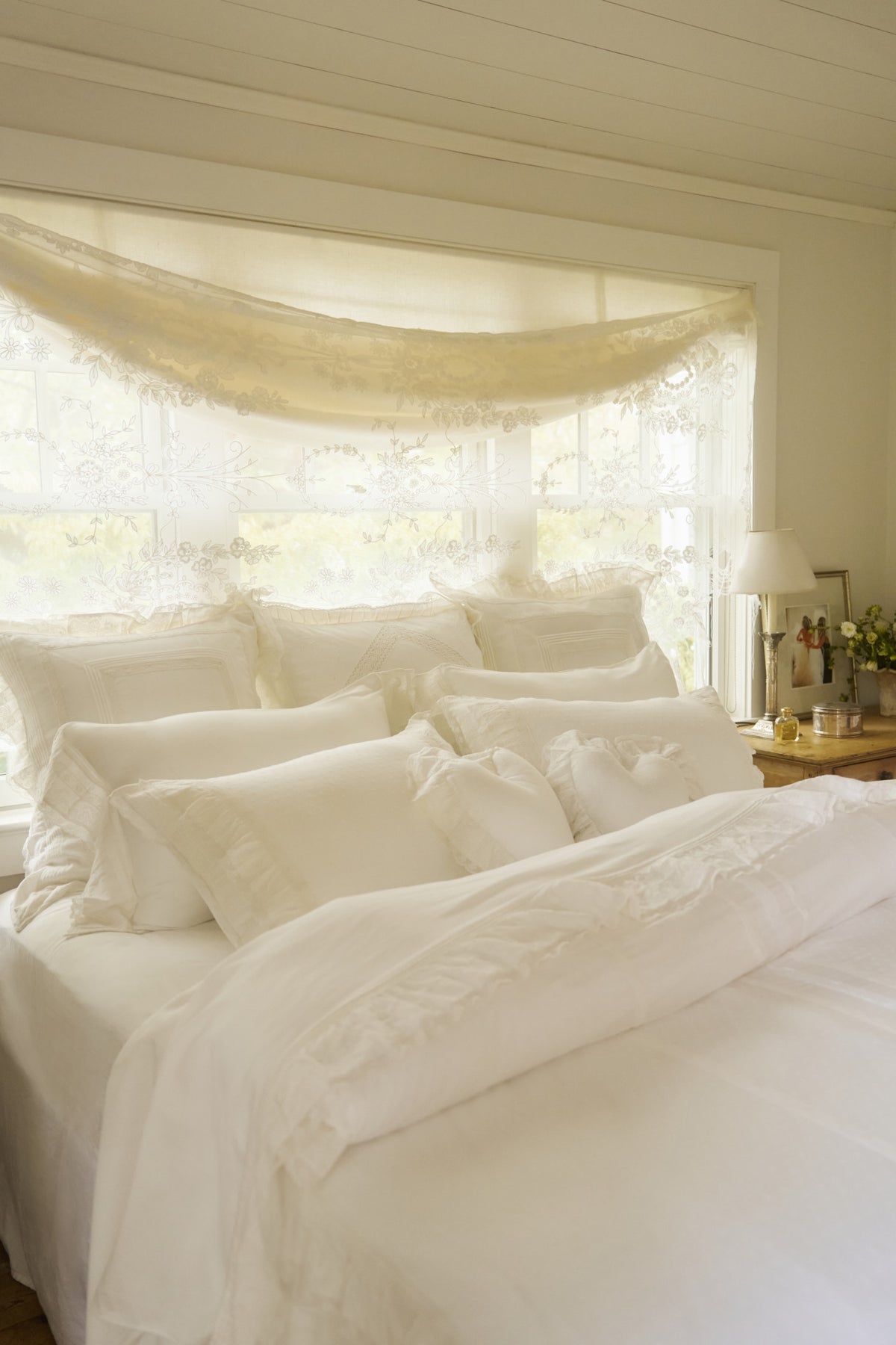 White sheet and pillowcase set with ruffled accents on bed