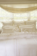 White Victorian duvet and shams with ornate ruffles and soft bedding layers