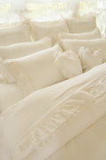 White Victorian-style bed sheet and ruffled pillowcase set with textured trim