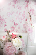 Pink floral rosette wallpaper pattern on pale background, straight wall section