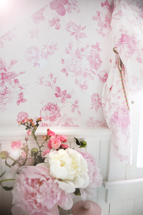 Pink floral rosette wallpaper pattern on pale background, straight wall section