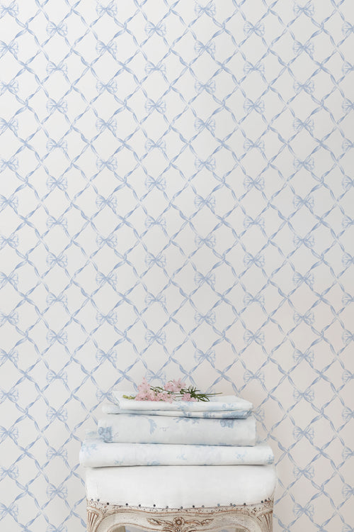 Light blue bow trellis pattern wallpaper on white background.