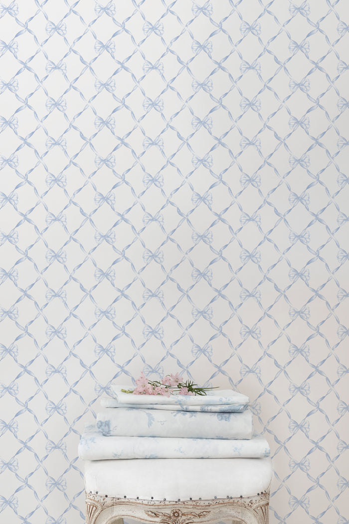 Light blue bow trellis pattern wallpaper on white background.