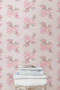 Pink and mint floral wallpaper pattern with roses and bow butterflies on a wall